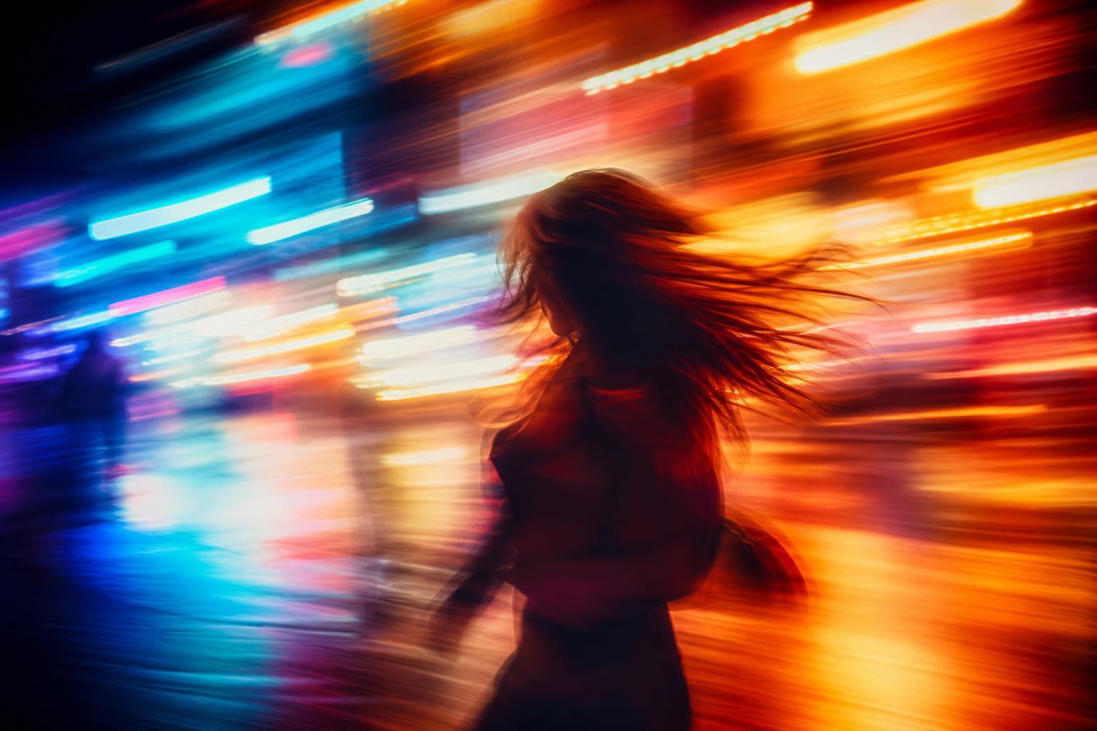 Silhouetted person in motion against streaks of orange, red, cyan, and blue city lights