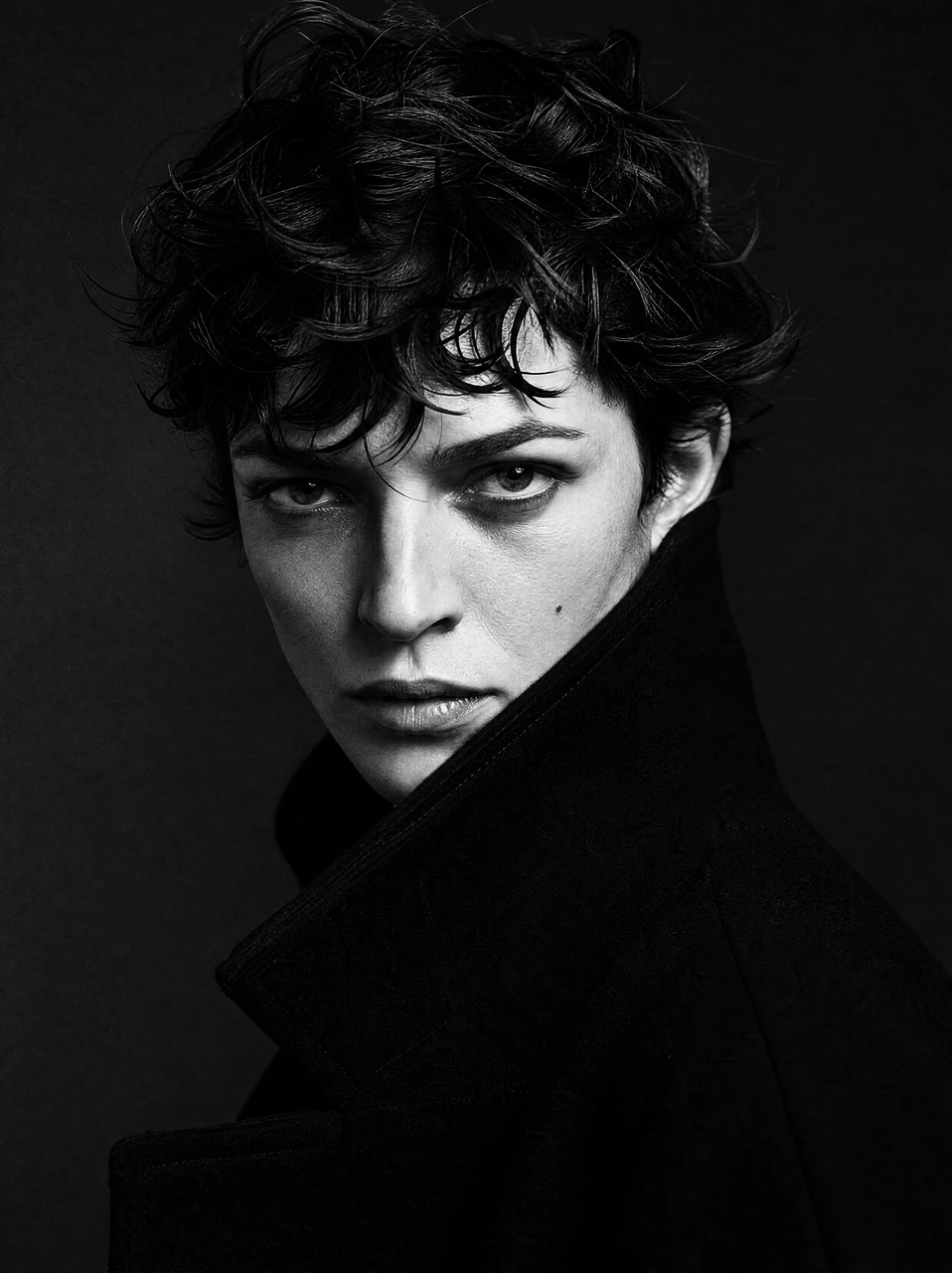 A dramatic monochrome close-up portrait template featuring short tousled hair, an intense gaze, and a bold high-collar coat for editorial fashion and artistic profile visuals.